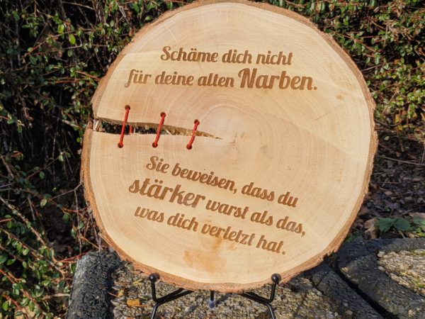 Baumscheibe "Alte Narben" mit inspirierender Botschaft. Eingebrannte Schrift auf einer natürlichen Baumscheibe aus heimischen Hölzern.